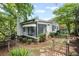 Backyard featuring mature trees, shrubs, and a sunroom extension at 881 Mclinden Se Ave, Smyrna, GA 30080
