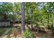 Backyard featuring mature trees, stone pathway and established greenery, with shed in the background at 881 Mclinden Se Ave, Smyrna, GA 30080