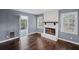 Inviting living room with a brick fireplace, wood floors, and natural light streaming through shuttered windows at 881 Mclinden Se Ave, Smyrna, GA 30080