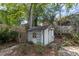 View of a small wooden shed in the backyard surrounded by trees and greenery at 881 Mclinden Se Ave, Smyrna, GA 30080