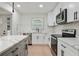A well-lit kitchen boasts white cabinets, stainless steel appliances, and a gray island with a waterfall countertop at 3176 Pollard St, Atlanta, GA 30344