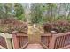 Wooden steps descending to a landscaped yard with flowering bushes and a charming fountain feature at 3595 Limberlost Sw Trl, Stockbridge, GA 30281