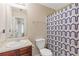 Neutral bathroom featuring a single sink vanity, toilet, mirror, and patterned shower curtain at 4474 Michael Jay St, Snellville, GA 30039