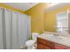 Bathroom featuring a toilet, shower with curtain, sink with wooden vanity, and mirror at 4474 Michael Jay St, Snellville, GA 30039