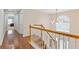 Hallway with hardwood floors, a wooden banister, and a modern light fixture at 4474 Michael Jay St, Snellville, GA 30039