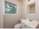 This is a bathroom with white cabinets, a window, toilet and sink at 1079 Stonewall Drive Southeast, Atlanta, GA 30315