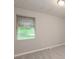 This bedroom has light gray carpet, one window and neutral painted walls at 1079 Stonewall Drive Southeast, Atlanta, GA 30315