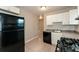 Kitchen featuring white cabinets, black appliances, and tile flooring at 1079 Stonewall Drive Southeast, Atlanta, GA 30315