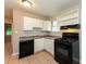 Kitchen featuring white cabinets, black appliances, and tile flooring at 1079 Stonewall Drive Southeast, Atlanta, GA 30315