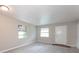 Bright living room featuring neutral paint, two windows, and a white entry door at 1079 Stonewall Drive Southeast, Atlanta, GA 30315