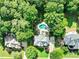 Aerial view of a home with a pool, surrounded by lush trees in a neighborhood setting at 121 Fairway Overlook, Woodstock, GA 30188