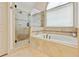 Elegant bathroom showcasing a luxurious soaking tub and a glass-enclosed shower with decorative tile accents at 121 Fairway Overlook, Woodstock, GA 30188