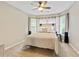 Serene bedroom with neutral tones, featuring a comfortable queen bed, windows, and wall-mounted reading lights at 121 Fairway Overlook, Woodstock, GA 30188