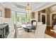 Dining room with wainscoting, decorative chandelier, and light-filled bay window with private views at 121 Fairway Overlook, Woodstock, GA 30188