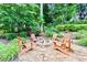 Cozy backyard firepit area with stone pavers and chairs surrounded by lush landscaping at 121 Fairway Overlook, Woodstock, GA 30188