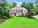 Charming brick home with manicured lawn, mature trees, black shutters, and inviting entrance with green lawn at 121 Fairway Overlook, Woodstock, GA 30188