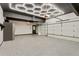 Clean three-car garage with epoxy flooring, storage shelves, and modern, stylish ceiling lights at 121 Fairway Overlook, Woodstock, GA 30188