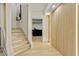 Hallway with light wood floors, staircase, and unique wall paneling at 121 Fairway Overlook, Woodstock, GA 30188