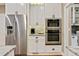 Modern kitchen with stainless steel refrigerator and appliances, custom cabinets, and marble counters at 121 Fairway Overlook, Woodstock, GA 30188