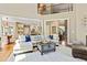 Open-concept living room with hardwood floors, neutral decor, and seamless flow to the kitchen and dining areas at 121 Fairway Overlook, Woodstock, GA 30188
