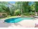 Beautiful backyard pool with lush landscaping, mature trees, and stone accents, creating a private outdoor retreat at 121 Fairway Overlook, Woodstock, GA 30188