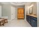 Bright bathroom featuring marble floors, blue vanity, and natural-stained armoire for plenty of storage at 210 Hunters Vw, Roswell, GA 30075