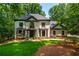 Charming two-story home featuring a manicured lawn and lush, mature landscaping at 210 Hunters Vw, Roswell, GA 30075