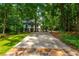 Beautiful home surrounded by mature trees with a long driveway and a manicured lawn at 210 Hunters Vw, Roswell, GA 30075