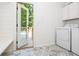 Clean laundry room with modern washer and dryer, access to a backyard deck, and storage solutions at 210 Hunters Vw, Roswell, GA 30075