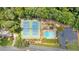 Aerial view of a community pool, tennis courts, and surrounding parking area surrounded by lush trees at 3158 Crestmont Nw Way, Kennesaw, GA 30152