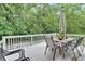 Back deck with an outdoor table, surrounded by lush greenery and trees for privacy at 3158 Crestmont Nw Way, Kennesaw, GA 30152