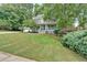 Beautiful home exterior featuring a well-kept lawn and mature trees surrounding the property at 3158 Crestmont Nw Way, Kennesaw, GA 30152