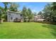 Spacious backyard with a lush green lawn, mature trees, and a wooden deck, great for outdoor activities at 5107 Rails Way, Norcross, GA 30071