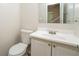 A bathroom has a white toilet, vanity, sink and cabinet with a large mirror at 5107 Rails Way, Norcross, GA 30071