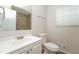 A clean bathroom featuring a white sink vanity, toilet, and a mirror reflecting a tiled shower at 5107 Rails Way, Norcross, GA 30071