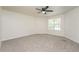 An empty bedroom features neutral walls, plush gray carpet, and a ceiling fan with overhead lighting at 5107 Rails Way, Norcross, GA 30071