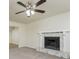 Cozy living room featuring a stone fireplace, neutral carpet, and a ceiling fan at 5107 Rails Way, Norcross, GA 30071