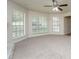 Spacious living room with neutral carpet, large windows, and a ceiling fan at 5107 Rails Way, Norcross, GA 30071
