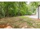 Large backyard with mature trees, a patio, a pool, and ample space for outdoor activities and enjoyment at 6394 Wood Valley Rd, Douglasville, GA 30134