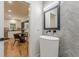 Stylish bathroom featuring herringbone-patterned tile, modern vanity and fixtures, and adjacent kitchen/living area at 6394 Wood Valley Rd, Douglasville, GA 30134
