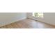Bright bedroom featuring light wood floors, white trim, and a sunny window view of the yard at 6394 Wood Valley Rd, Douglasville, GA 30134