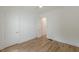 Bright bedroom with wood-look floors, white trim, ceiling fan, and a glimpse into an adjacent room at 6394 Wood Valley Rd, Douglasville, GA 30134