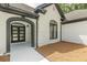 Arched entry to a white brick home with black trim and modern glass doors at 6394 Wood Valley Rd, Douglasville, GA 30134