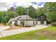 Beautifully landscaped home with a white brick facade and a two-story guest house at 6394 Wood Valley Rd, Douglasville, GA 30134