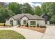 Stunning white brick home with dark trim, manicured lawn, and a circular driveway at 6394 Wood Valley Rd, Douglasville, GA 30134