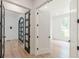 Hallway showcasing light wood-look floors with clear views to other rooms and unique black doors at 6394 Wood Valley Rd, Douglasville, GA 30134