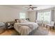 This bright main bedroom features hardwood floors, a ceiling fan, and a comfortable sitting area at 6394 Wood Valley Rd, Douglasville, GA 30134
