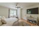 Bright main bedroom features hardwood floors, ceiling fan, sitting area, and large-screen TV at 6394 Wood Valley Rd, Douglasville, GA 30134