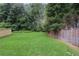 Large backyard with lush green grass, mature trees, and a privacy fence at 1911 Stancrest Nw Trce, Kennesaw, GA 30152