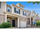 Two-story townhome exterior with brick accents, siding, and individual garages at 2725 Morgan Glen Rd, Buford, GA 30519